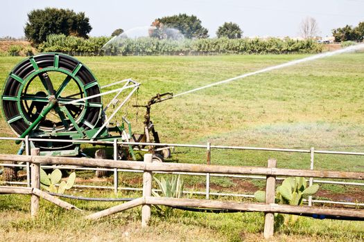 Irrigation operations in Italian country during a sunny day
