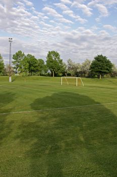 A cloudy unoccupied soccer field with trees in the background. (HDR photograph)
