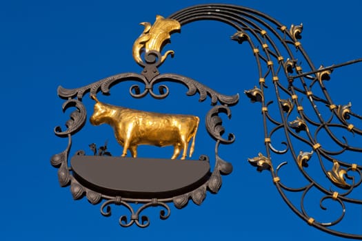 Beautifully crafted wrought iron sign with golden ox with empty copyspace for your message.