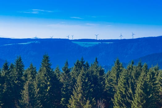 Forested landscape with windfarm at horizon in Black Forest, rural Germany.