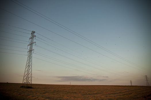 landscape with high tension wires over sky