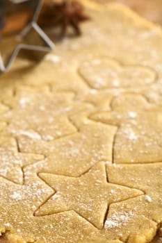 Christmas shapes cut out on cookie dough (Selective Focus, Focus on the right lower part of the star shaped cookie)