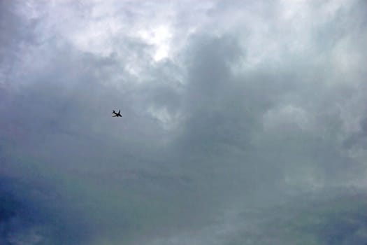 A plane flying through the air in strong cloud