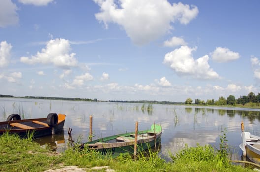 Boats resting on the lake coast with nice view of lake.