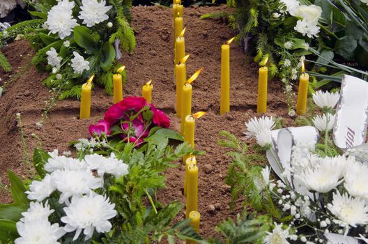 Cross formed from the candle on the newly formed grave.