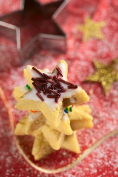 Star-shaped cookie with chocolate sprinkles on top of a cookie pile (Selective Focus, Focus one third into the top of the cookie)