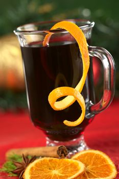 Hot spiced mulled wine garnished with orange peel (Selective Focus, Focus on the front rim of the glass and the orange peel at the rim)