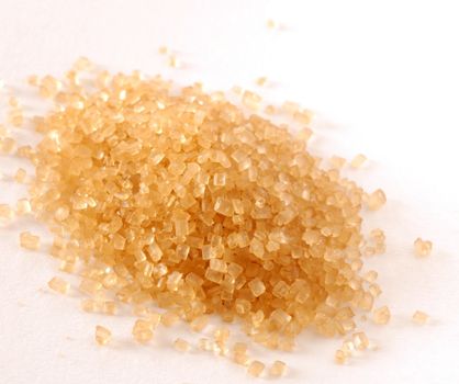 heap of yellowish brown sugar over white background