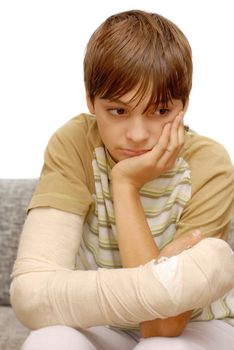 sad teenage caucasian boy with broken arm bone