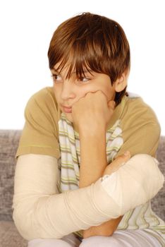 sad teenage caucasian boy with broken arm bone