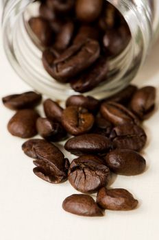 Coffee beans in and out of a jar of glass.