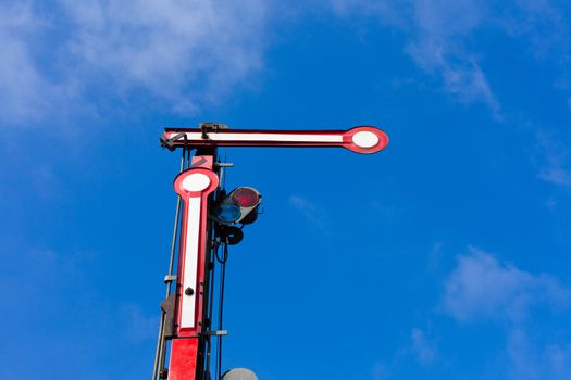 Old railway semaphore against blue sky.