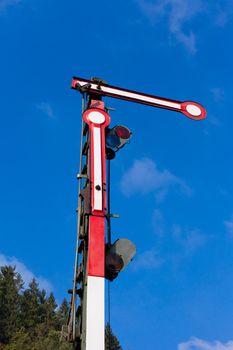 Old railway semaphore against blue sky.