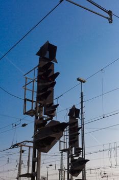 Red railway electric signal light and electric overhead contact wire all over.