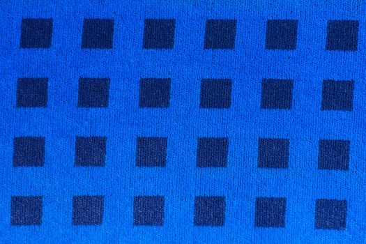 Blue woven fabric with pattern of darker squares.