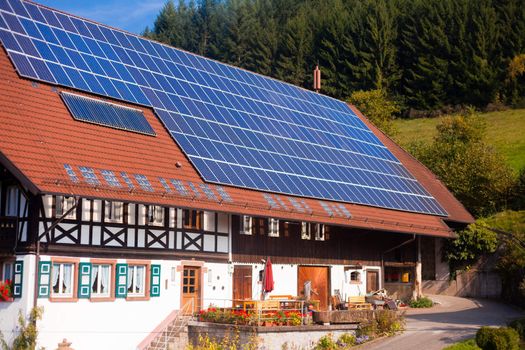 Historic Black Forest (Germany) farm house with modern solar panels on large roof.