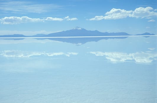 Reflection of distant hills and sky in the Salar de Uyuni salt lake, Bolivia