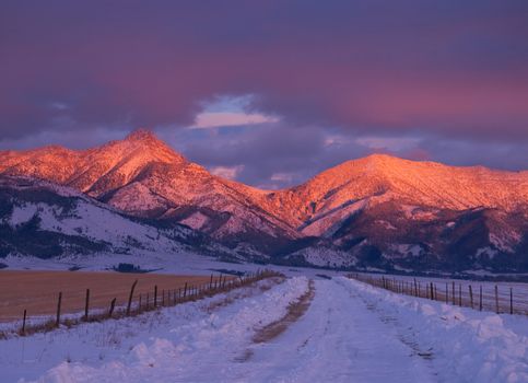 Winter Road, Ross Peak (center left, 9,0004 ft. elevation) and clouds at sunset, Gallatin County, Montana, USA