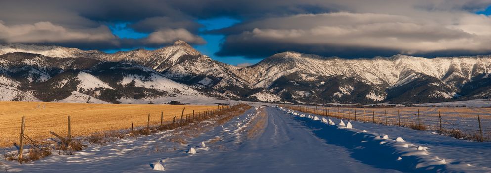 Winter Road, Ross Peak ( center left, 9,004 ft. elevation) and clouds, Gallatin County, Montana, USA