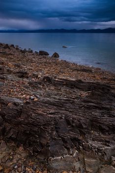 The rocky shore of Flathead Lake on a stormy evening in spring, West Shore State Park, Flathead County, Montana, USA