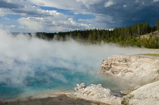 Excelsior Geyser, Lodgepole Pine (Pinus contorta) forest and storm clouds, Yellowstone National Park, Park County, Wyoming, USA