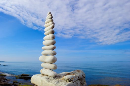 Stack of white pebbles in the balance on the seacoast