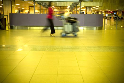 Woman with luggages at the airport with motion blurred