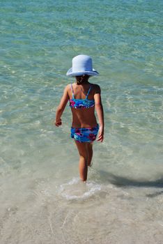 small girl walking into the sea