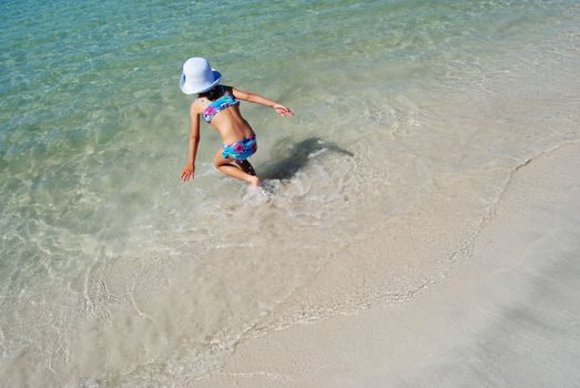 little girl running into the ocean