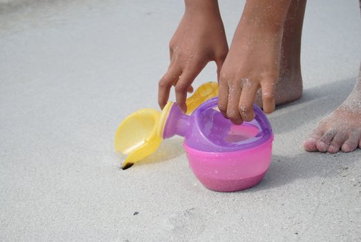 kids hand and toys in the sand