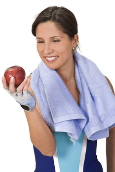Relaxed young woman in fitness equipment holding an apple.Ideal image to illustrate the concept of healthy lifestyle (sport and correct nutrition).