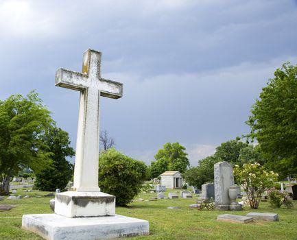 Graveyard scene with cross and gravestones.