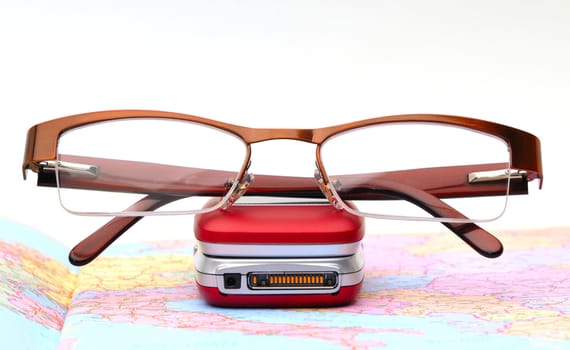 Modern glasses on telephone, background map and white