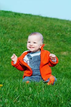 smiling baby sitting on green grass