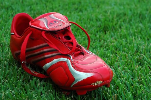 red soccer shoe on green field