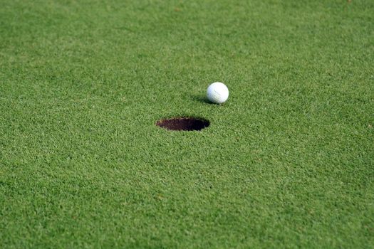 Golf ball in front of the hole