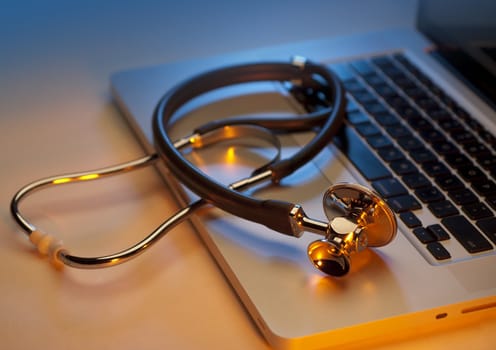 Medical stethoscope on a laptop computer, closeup