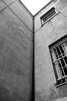 Abandoned building exterior. Broken window and weathered wall.