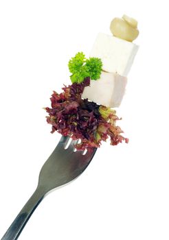 Fresh vegetables on a fork isolated on white background