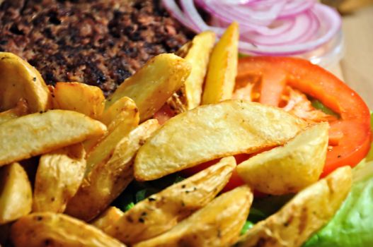 Burger with french fries, tomato and onions. Fast food background.