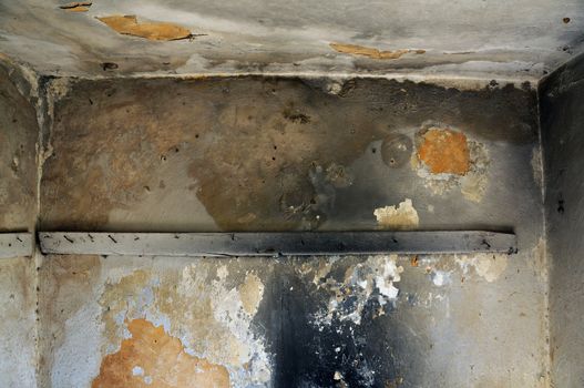 Empty room and moldy crumbling wall texture. Abandoned house interior.