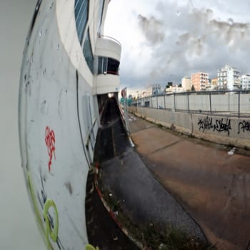 Distorted view of cityscape in the rain mirrored on convex parking mirror.