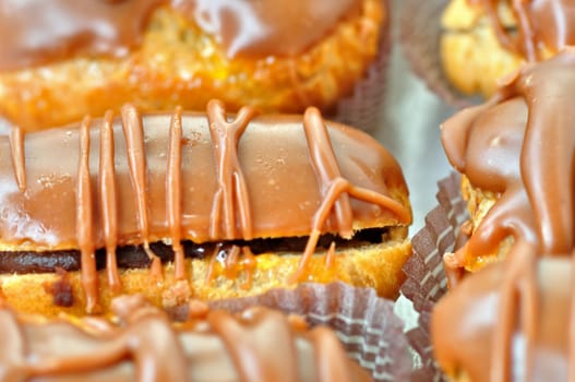 Eclair dessert covered with chocolate. Selective focus.