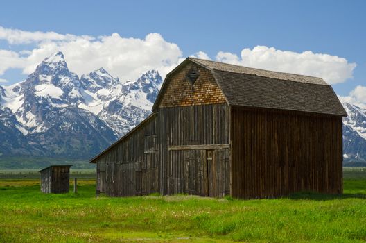 Old barn and The Teton Mountain Range in early summer, Grand Teton National Park, Teton County, Wyoming, USA