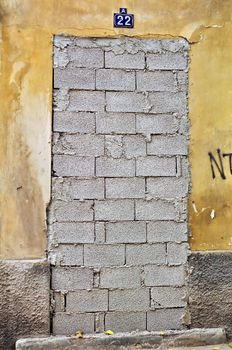 Bricked up door and weathered wall of an abandoned building.