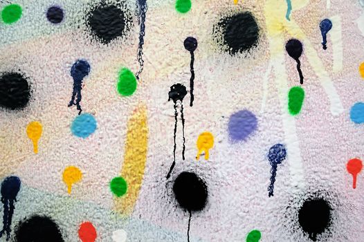Textured wall covered with dots of dripping paint.