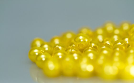 Yellow beads on bluish surface with mirror image