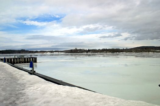 A lake and dock iced over in the winter