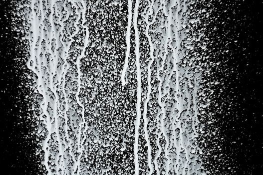 White paint splashed over black background. Abstract texture.