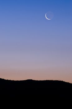 Crescent Moon above a ridge in morning twilight, Grand Teton National Park, Teton County, Wyoming, USA
